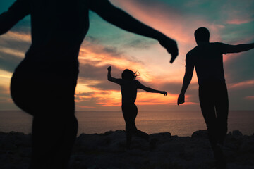 Friends silhouettes having fun together at sunset