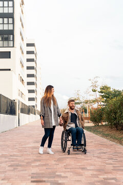 Happy disabled man in Wheelchair Talking with Girlfriend