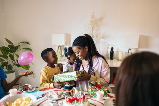 Little black boy giving his older sister a present on her birthday.