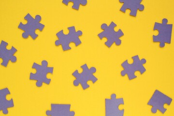 Violet mosaic game details of jigsaw puzzle elements on yellow background. Completing task or solving problem concept. World mental health day, autism awareness day. Global communication. Hobby, play