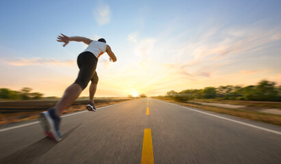 Fototapeta na wymiar Action motion blur of a man running on country road with sunrise background...