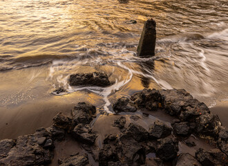 Waves Washing Over Lava Rocks at Sunrise on Hana Bay Beach Park, Hana, Maui, Hawaii, USA