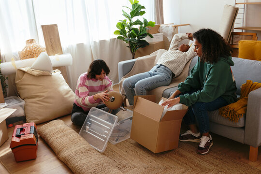 Female flatmates unpacking boxes at new home