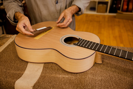 Unrecognizable luthier working on classic guitar