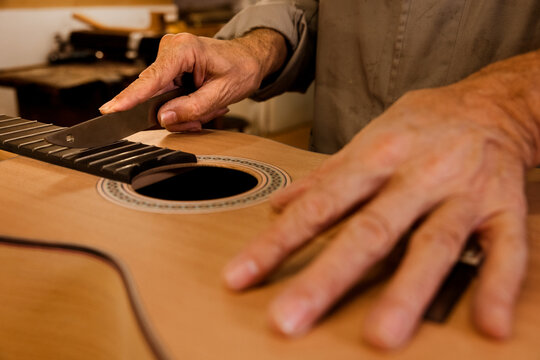 Crop luthier working in custom classic guitar