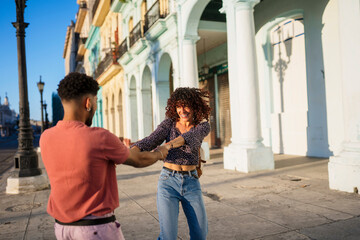Cuban couple holding hands spinning around
