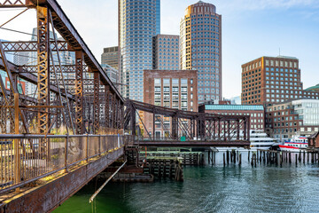 Rusty abandoned truss bridge and skyscrapers of down town in the bay on the modern waterfront in Boston in New England