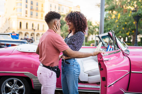 Romantic couple near pink old timer in city