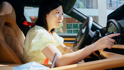 woman driver touches control screen in modern electric car