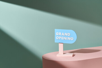 Text on vintage color sign "Grand Opening" on pastel podium