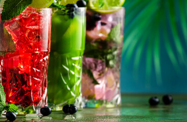 Summer refreshing alcoholic cocktails with gin, tequila, vodka, lime, mint and ice, copy space. Tropical style cocktail party.