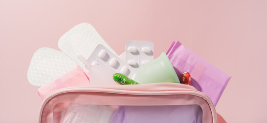 Pink bag with medicines and pads during menstruation.