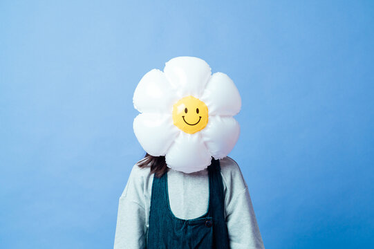 Cute girl with a balloon hiding her head