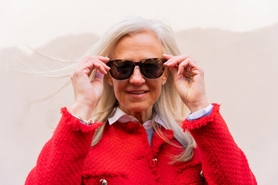 Portrait Of A White Hair Woman With Red Jacket And Sunglasses.