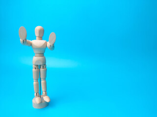 Wooden mannequin on a blue background with copy space.
