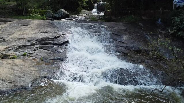 Drone climbing waterfall filming very close to the water, nature and stones