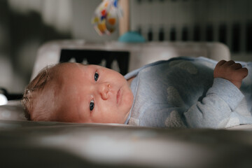 Close up of infant boy on floor in nursery.