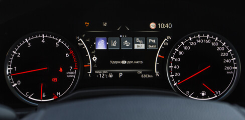 Close up shot with the digital car dashboard. Illuminated car dashboard. Translation "Hold OK to settings.Temp. outside"