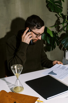 Man talking on phone in his home office