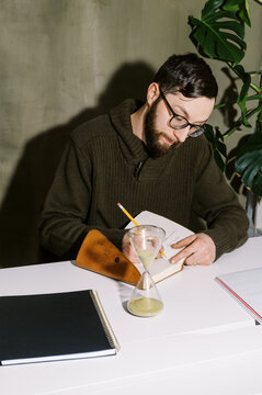 portrait of young man sitting at desk writing