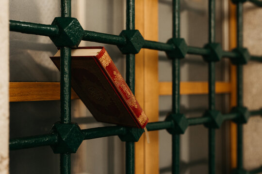 red book on a metal window fence