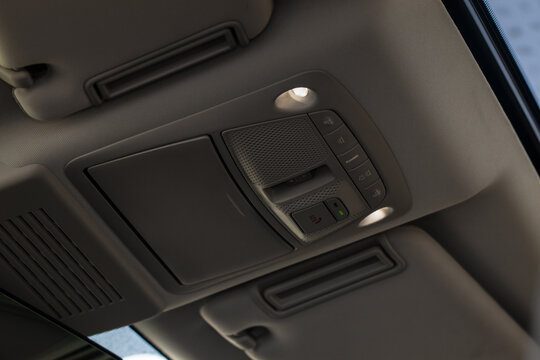 Close up image of the SOS button and car ceiling lamp in a car.
