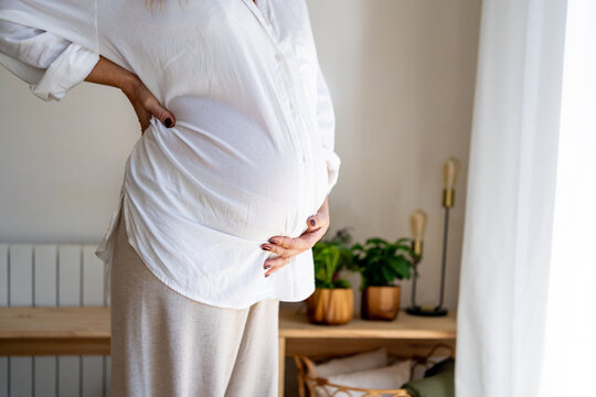 detail of belly of pregnant woman at home 