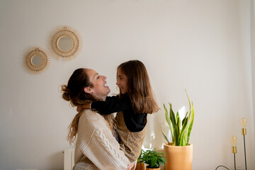 Happy mother dancing with daughter at home