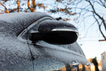Car Covered in Light snow frost with side view mirror 