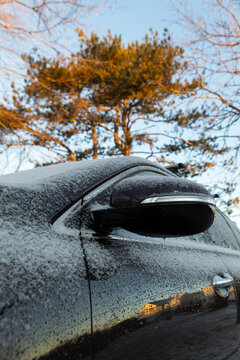 Fototapeta Car Covered in Light snow frost with side view mirror in driveway