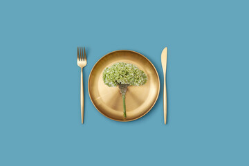 Celosia flower on plate with knife and fork.