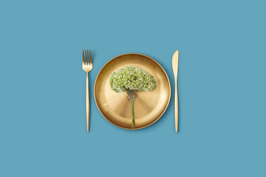 Celosia flower on plate with knife and fork.