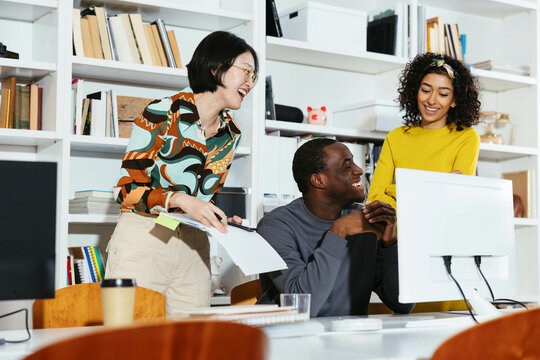 Cheerful diverse colleagues working on project in office