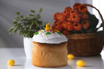 Traditional Easter cake with swiss meringue and spring decoration, orange tulips on background. Happy Easter. Recipe of Easter bakery. Festive pastry for spring holidays.