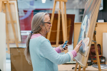 Woman painting with pastel technique in art school studio
