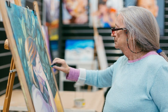 Woman painting with pastel technique in art school studio