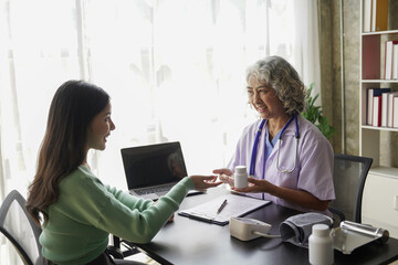  consulting female patient about pills and discussing health treatment sitting in the office at the desk. Medicine and health care concept. Doctor prescribing medicine to patient in the office.