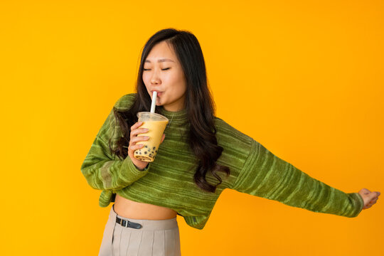 Asian female drinking bubble tea in studio