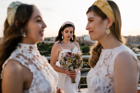 Young bride near bridesmaids on terrace