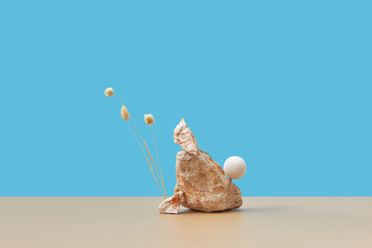 Stone with natural plants and white sphere.