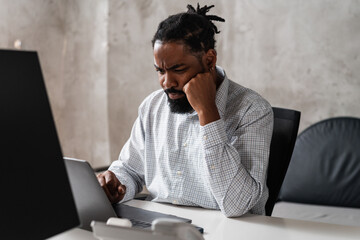 Man In The Office Looking At Computer And Frowns