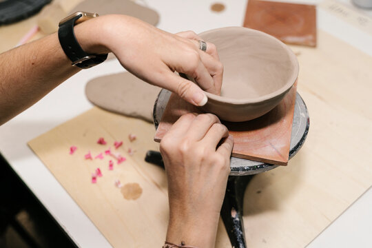 Unrecognizable artisan shaping clay bowl in pottery