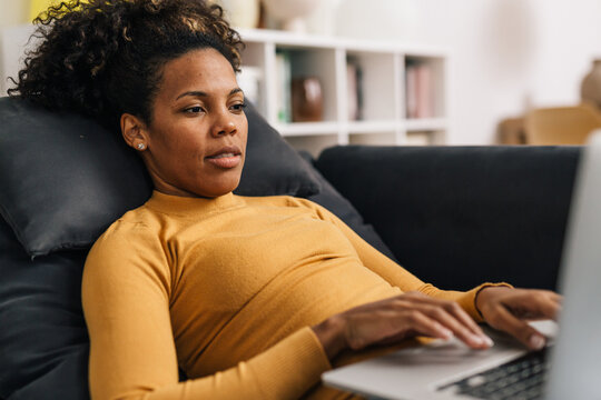 Mixed Race Woman Looks At The Laptop At Home