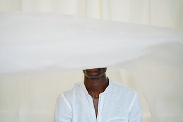 Man in stylish white clothes on white backdrop.