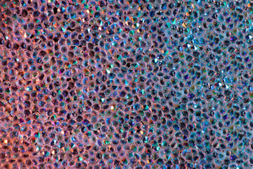 Abstract rhinestones background. Texture of rhinestones illuminated with multi-colored light. Pink...