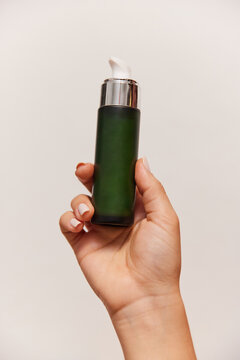 Hand holding skincare tube