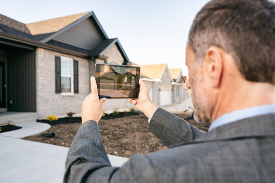 Agent Takes Photo Of Elevation With Tablet