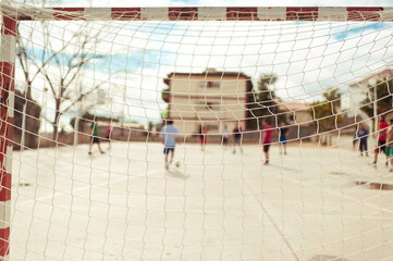 Goal net with friends playing soccer in background