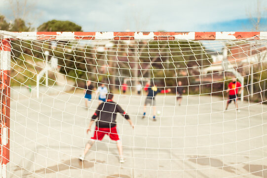 Goal net with blurred friends playing soccer 