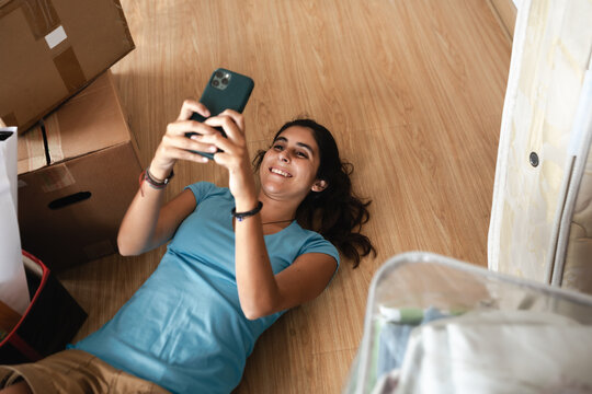 woman lying on the floor with home moving boxes